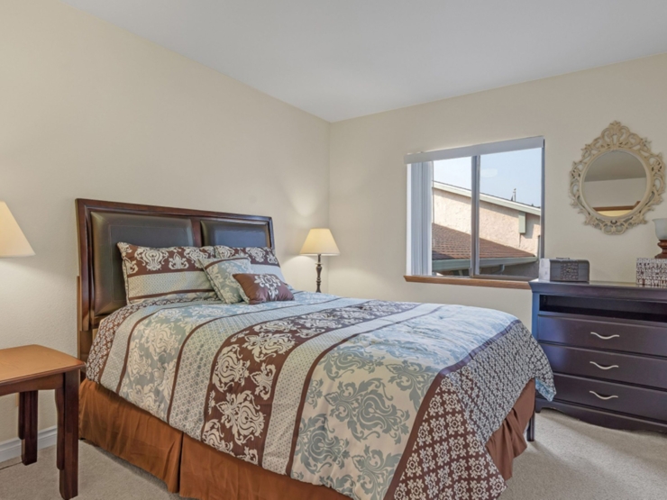 A cozy bedroom filled with warmth, featuring a beautifully made bed, soft lighting, and inviting decor.