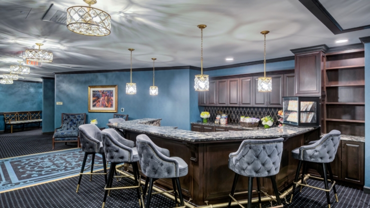 A stylish lounge area featuring a welcoming bar, elegant decor, and comfortable seating for socializing.