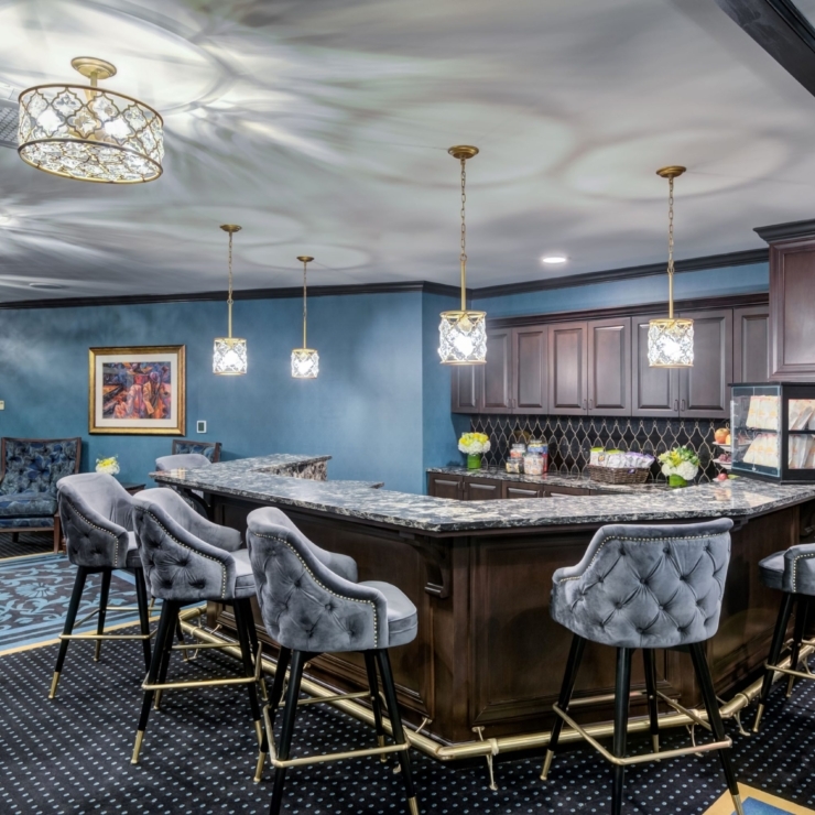 A stylish lounge area featuring a welcoming bar, elegant decor, and comfortable seating for socializing.