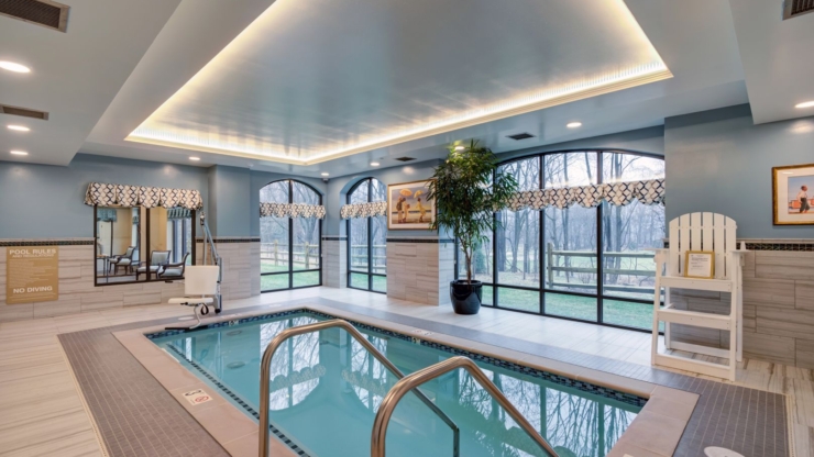 A serene indoor pool area, featuring natural light, inviting decor, and a sense of community warmth.