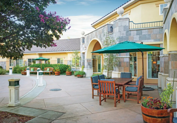 A welcoming outdoor space with shaded seating invites relaxation and connection among residents.