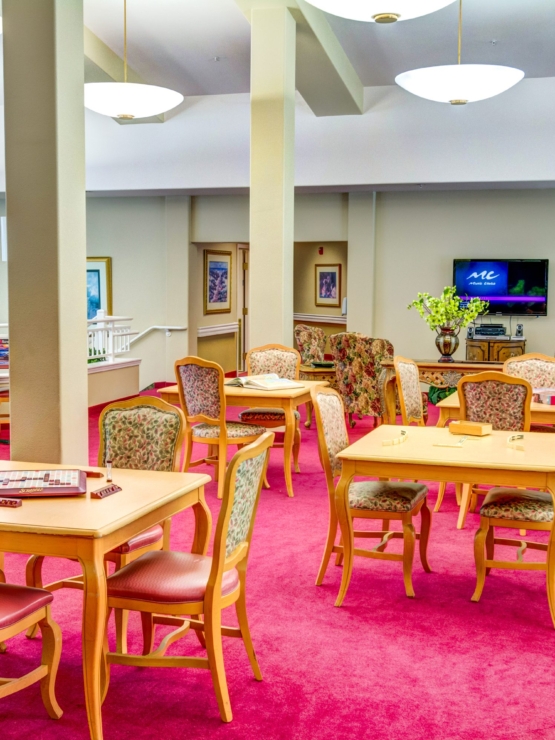 Bright, inviting communal space with cozy seating and engaging activities fosters connection and joy.