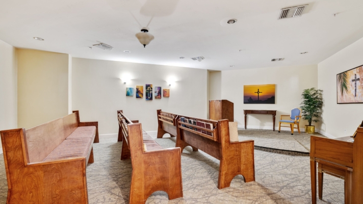A serene chapel with warm wooden benches, inviting artwork, and a peaceful atmosphere for community gatherings.