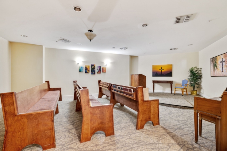 A serene chapel with warm wooden benches, inviting artwork, and a peaceful atmosphere for community gatherings.
