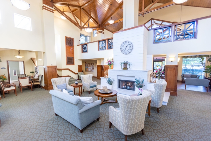 A welcoming lounge with cozy seating, a warm fireplace, and vibrant floral accents fosters community and comfort.