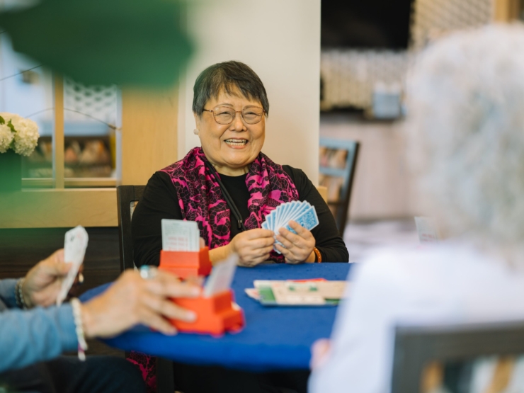 Lively card game among friends, filled with laughter and warmth in a welcoming community space.