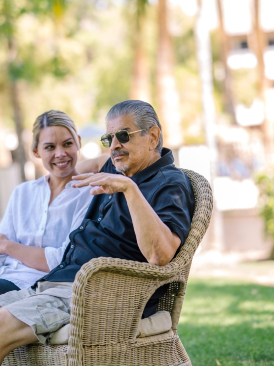 A joyful conversation unfolds in a sunlit garden, highlighting warmth and connection in the community.