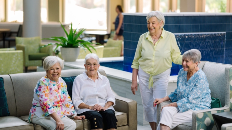 A vibrant gathering of residents enjoying laughter and friendship in a welcoming lounge area.