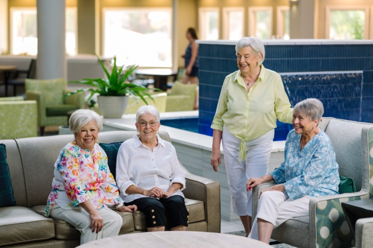 A vibrant gathering of residents enjoying laughter and friendship in a welcoming lounge area.