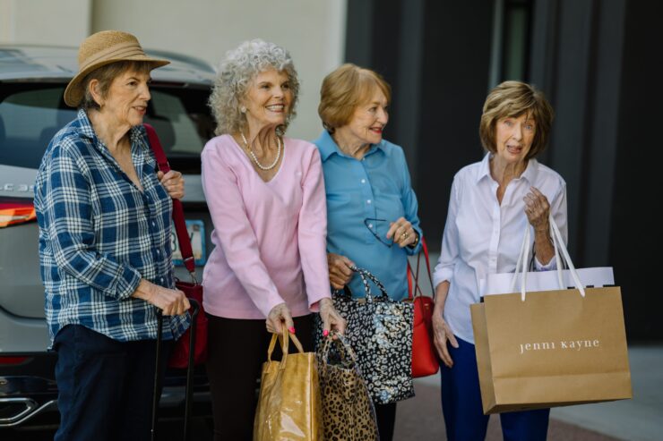 Four cheerful women enjoy a day out, sharing laughter and shopping bags, radiating community spirit.