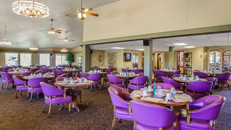 Bright and inviting dining area with cozy purple seating, fostering community and warmth.