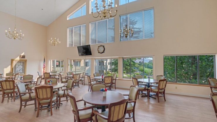 Bright and inviting gathering space with ample seating, large windows, and a serene outdoor view.