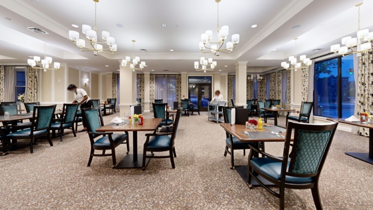 A welcoming dining area filled with light, featuring elegant tables and attentive staff, fosters community.