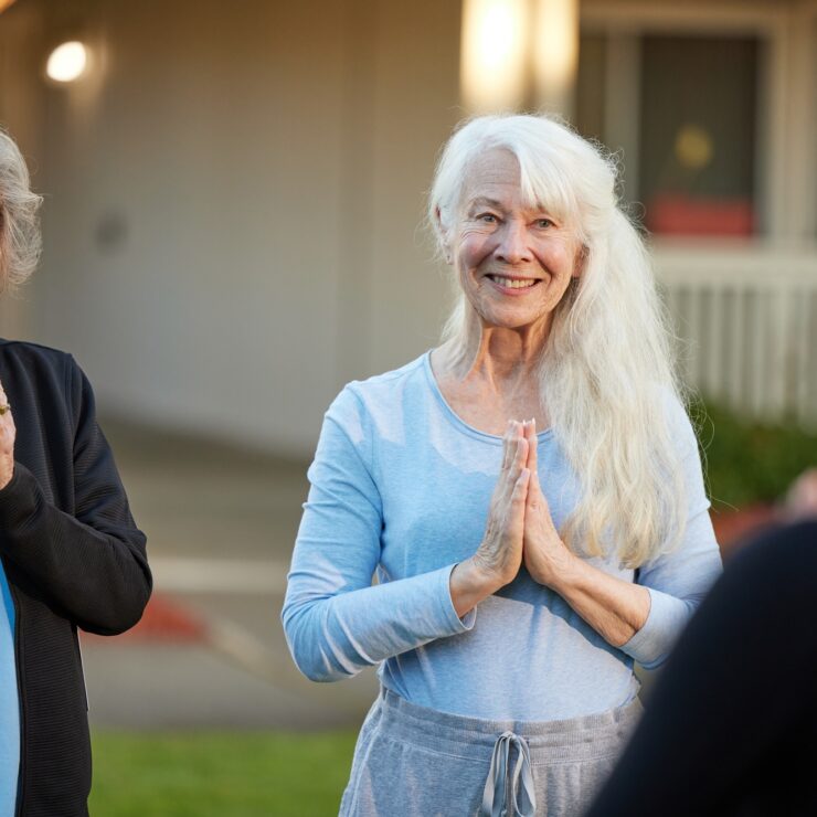 Two smiling women engage warmly in conversation, fostering a sense of community and connection.