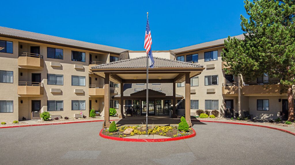 The welcoming entrance of Solista Longmont, surrounded by vibrant landscaping, fostering a sense of community and comfort.