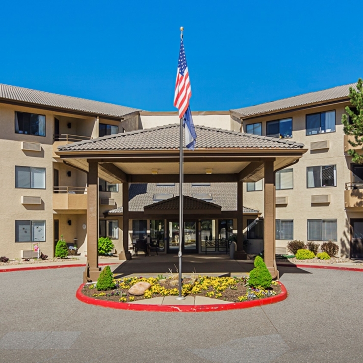 The welcoming entrance of Solista Longmont, surrounded by vibrant landscaping, fostering a sense of community and comfort.