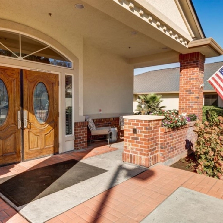 Welcoming entrance with elegant doors, vibrant flowers, and a friendly atmosphere for all residents.