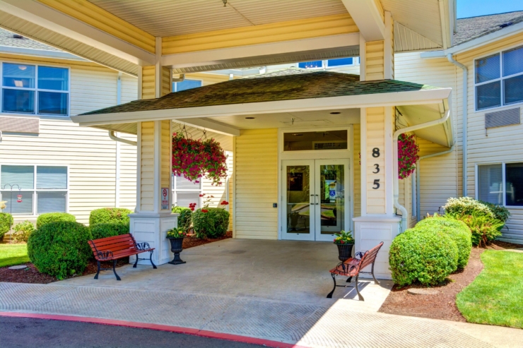 Welcoming entrance adorned with vibrant flowers, inviting benches, and a warm, friendly atmosphere.