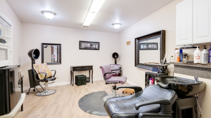 A welcoming salon space designed for relaxation, featuring comfortable chairs and bright lighting.