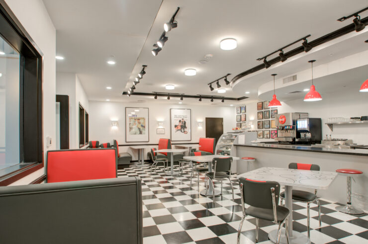 Bright and inviting dining area with classic checkered floors, red accents, and comfortable seating.