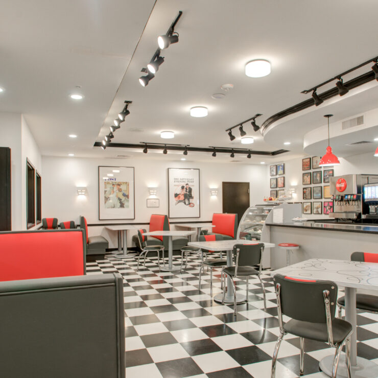Bright and inviting dining area with classic checkered floors, red accents, and comfortable seating.