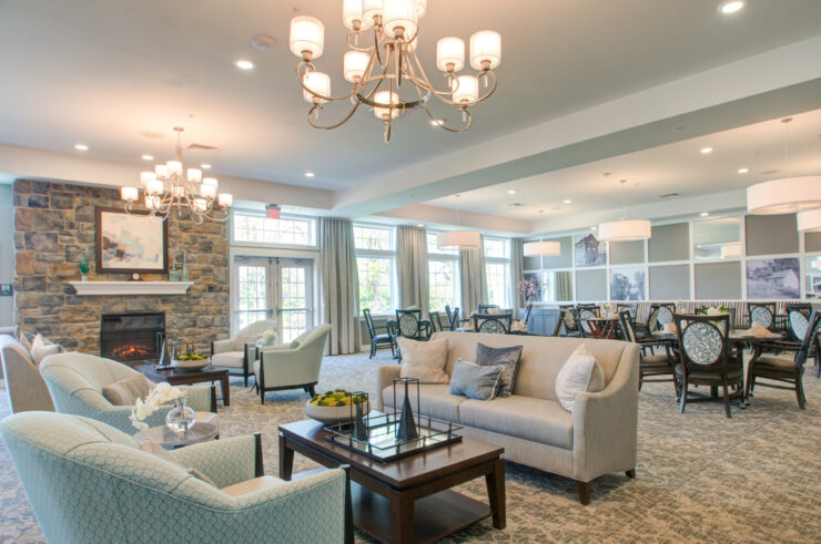 Spacious, well-lit lounge and dining area with comfortable seating and a warm fireplace.