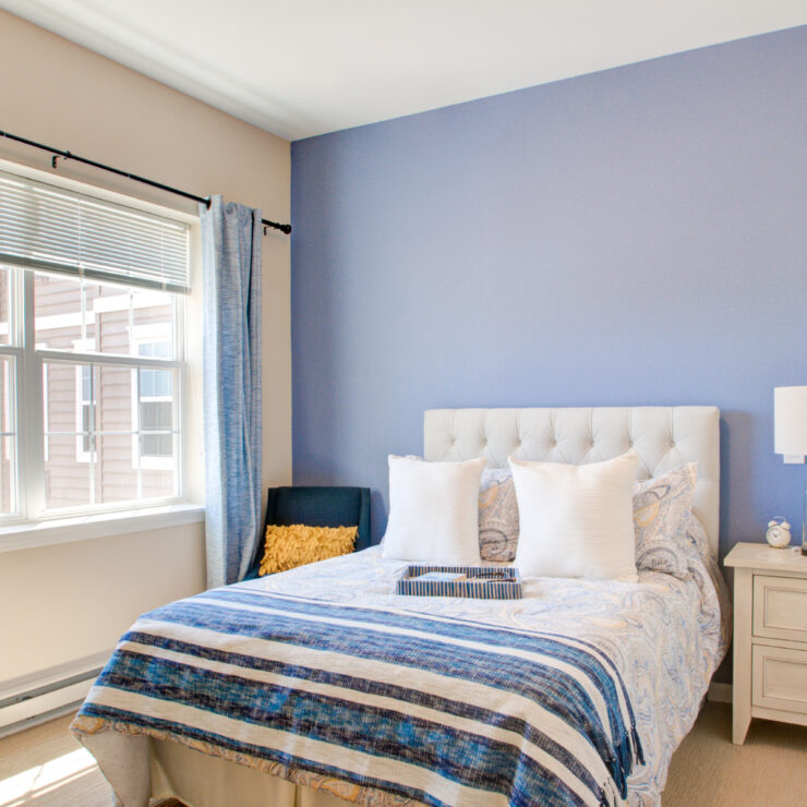 Bright and inviting bedroom designed for comfort, featuring soft bedding and natural light.