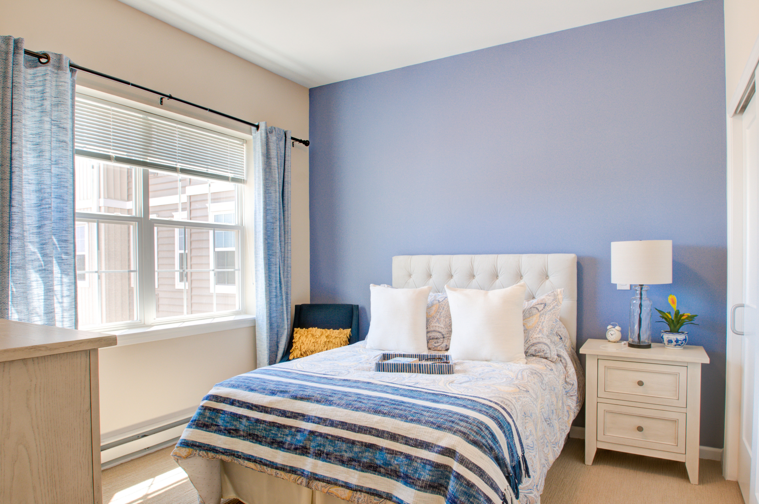 Bright and inviting bedroom designed for comfort, featuring soft bedding and natural light.