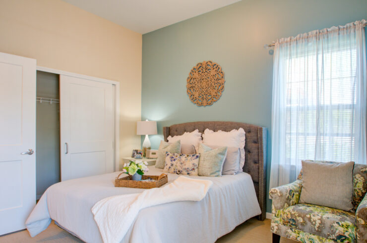 Bright and inviting bedroom featuring comfortable bedding, soft lighting, and a relaxing armchair.