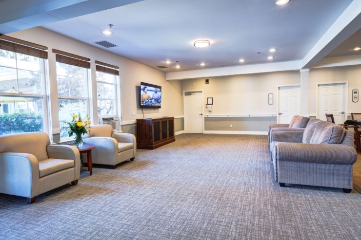 A welcoming lounge filled with cozy seating, bright windows, and a warm atmosphere for community gatherings.