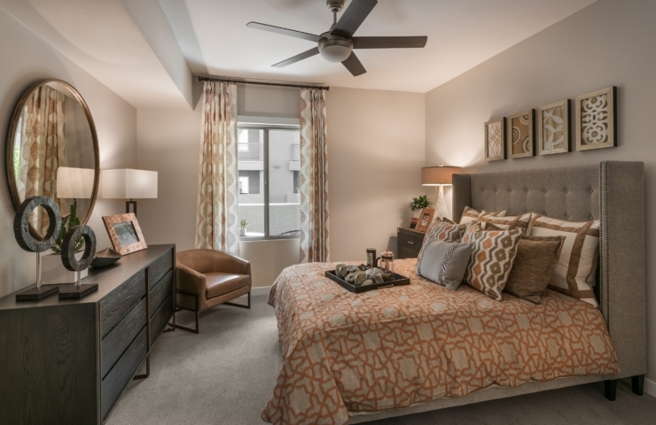 A serene bedroom with warm decor, inviting comfort, and natural light, perfect for peaceful living.
