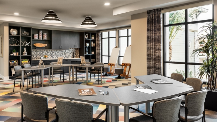 A bright, inviting activity room with modern furnishings, perfect for community gatherings and creativity.