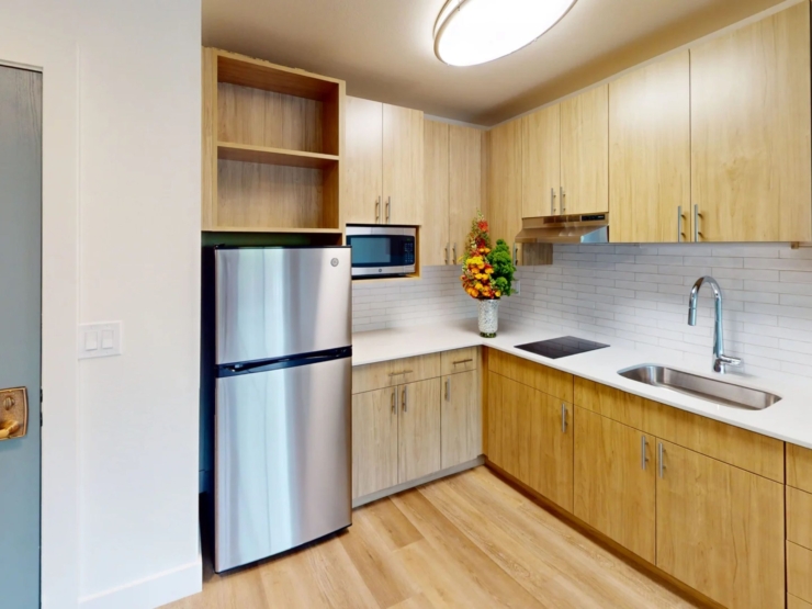 A bright, welcoming kitchen featuring warm wood tones and modern appliances, perfect for community gatherings.