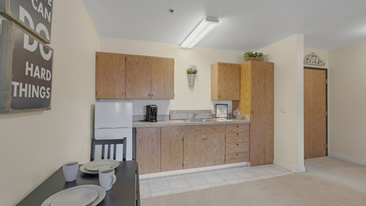 A bright, inviting kitchen area with warm cabinetry, perfect for community gatherings and comfort.