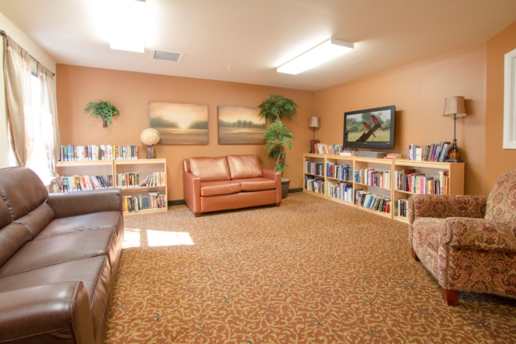 A cozy, inviting lounge filled with books, comfortable seating, and warm lighting, perfect for community gatherings.