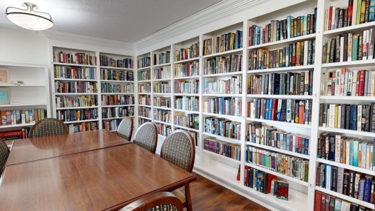 A cozy reading room filled with books, inviting chairs, and warm lighting, perfect for community gatherings.