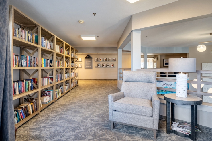 A cozy corridor filled with bookshelves, inviting seating, and warm lighting, perfect for community connections.