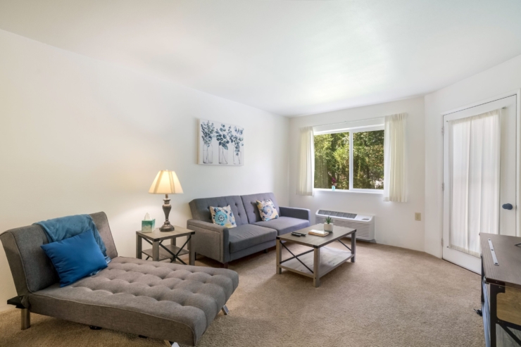 A cozy, sunlit living area invites relaxation, featuring comfortable seating and warm decor.