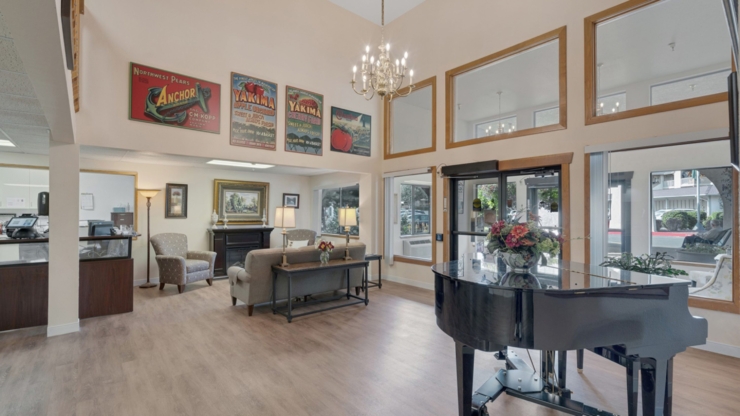 A welcoming space featuring a piano, comfortable seating, and bright natural light, fostering connection and warmth.