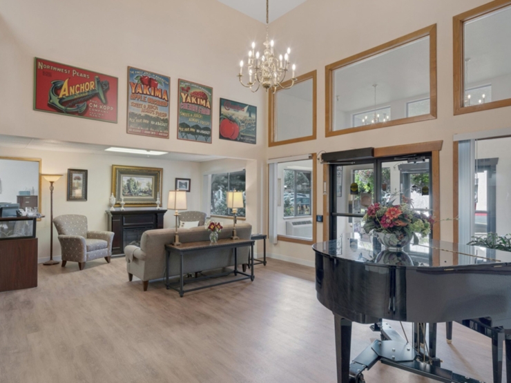 Welcoming common area with cozy seating, lively decor, and a grand piano, fostering community warmth.