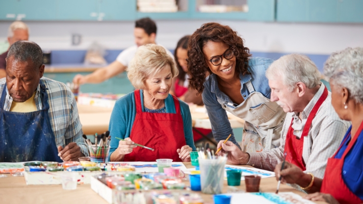 Residents engage in a joyful art class, fostering creativity and connection in a warm, inviting atmosphere.