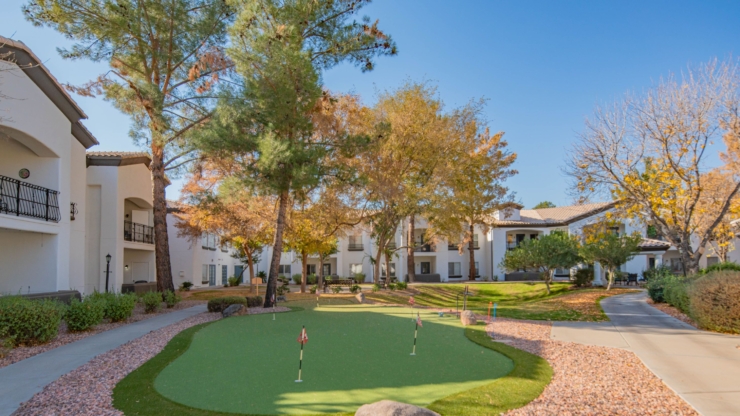 A vibrant community space with lush greenery, inviting pathways, and cheerful autumn colors.
