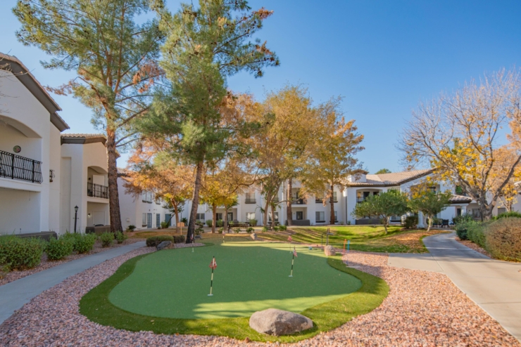 A vibrant community space with lush greenery, inviting pathways, and cheerful autumn colors.