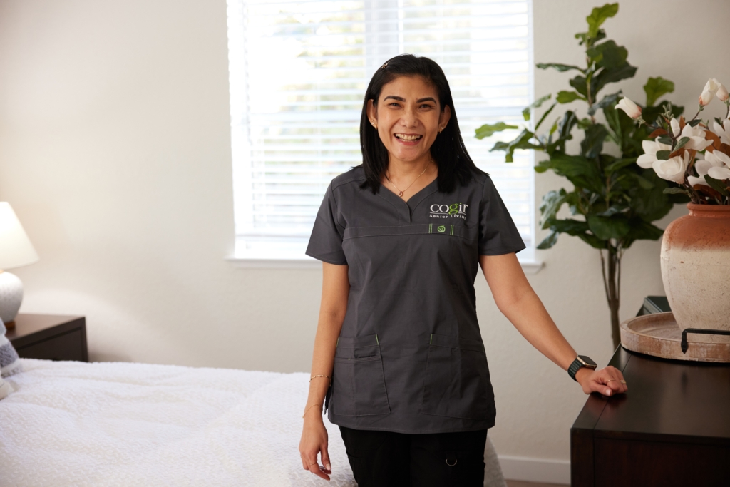 A welcoming staff member stands in a bright, cheerful room, embodying community and care.