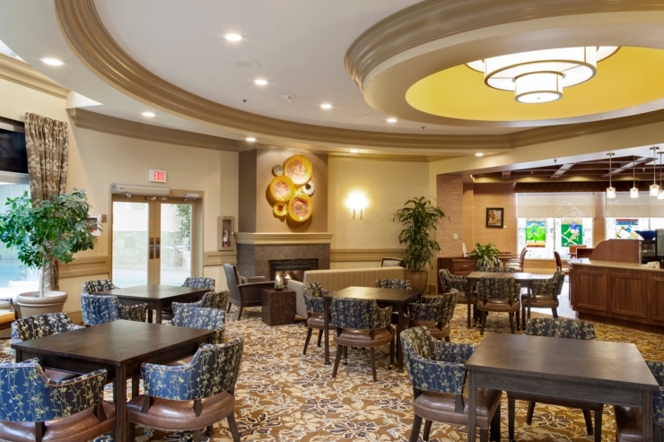 A welcoming lounge with elegant decor, inviting tables, and lush plants, perfect for community gatherings.