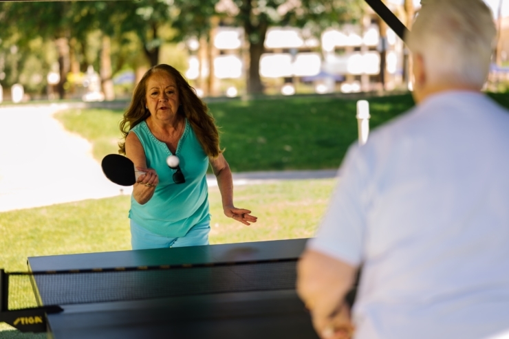 Engaging residents enjoy a lively game of table tennis, fostering connection and joy outdoors.