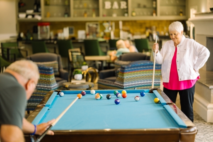 Residents enjoy a friendly game of billiards, fostering connection and joy in a vibrant community space.