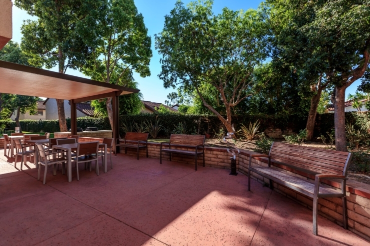 A serene outdoor space with comfortable seating, surrounded by lush greenery, perfect for community gatherings.