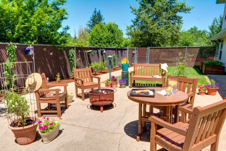 A sunny outdoor space filled with cozy seating, vibrant flowers, and a welcoming atmosphere.