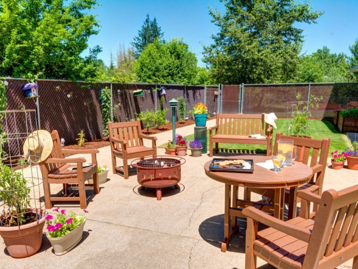 A sunny outdoor space filled with cozy seating, vibrant flowers, and a welcoming atmosphere.